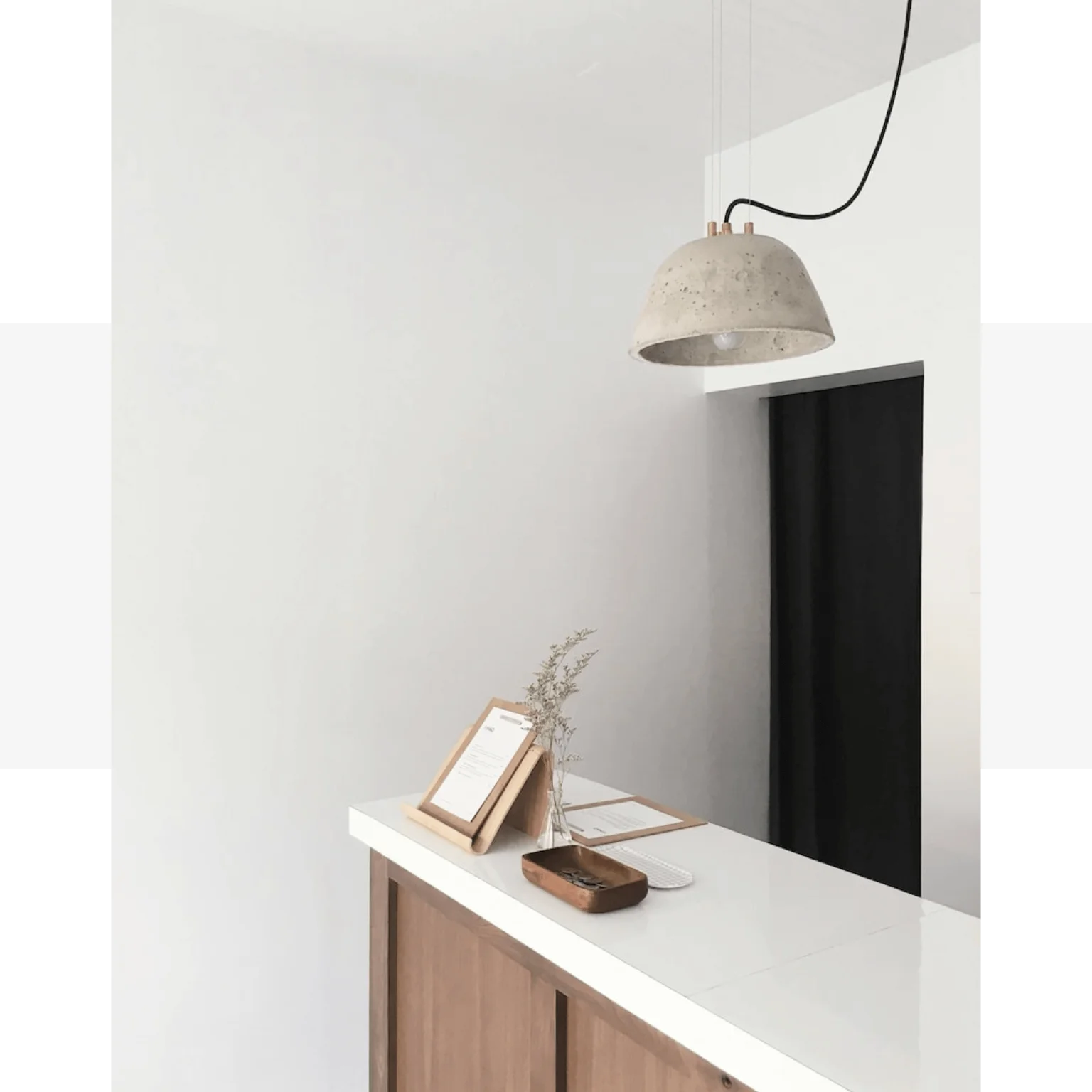 A white desk with a quartz lamp hanging over it.